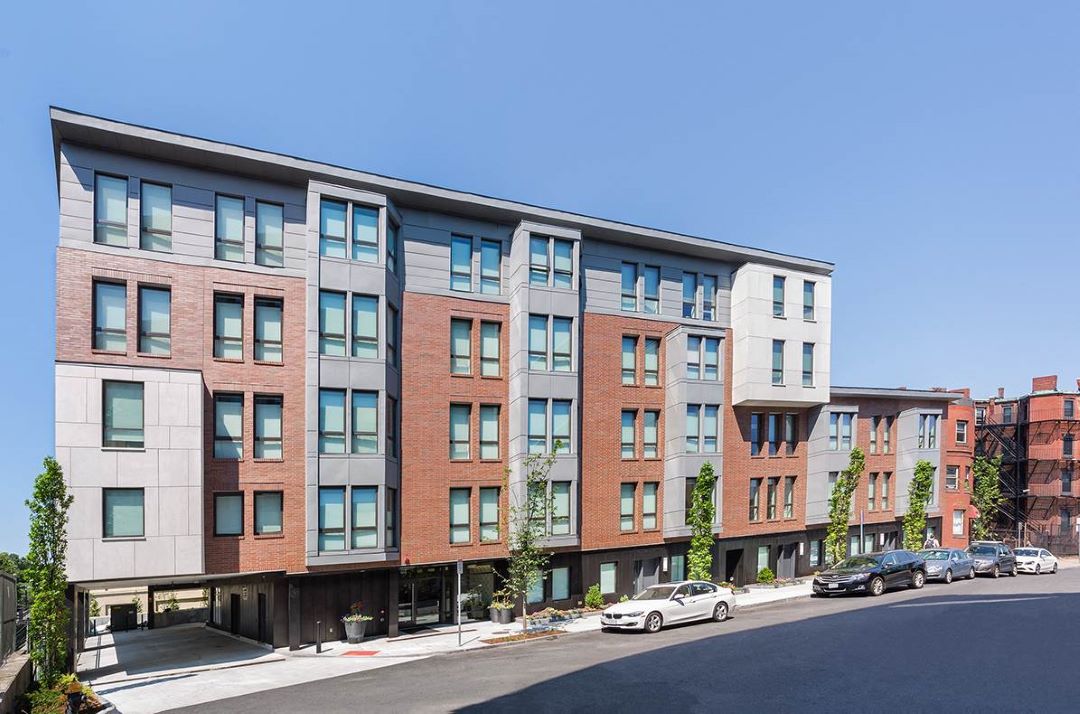 multi-story apartment building with brick exterior and large windows