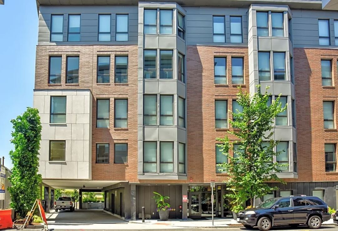 multi-story apartment building with brick exterior and large windows