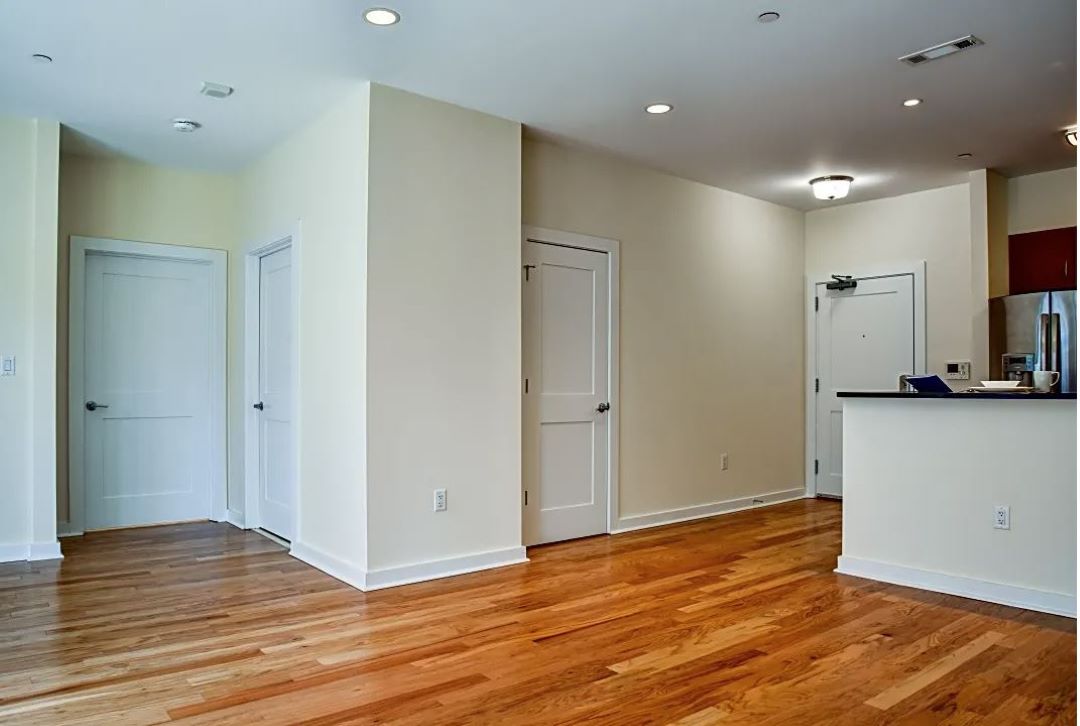 modern living area with large windows open to kitchen