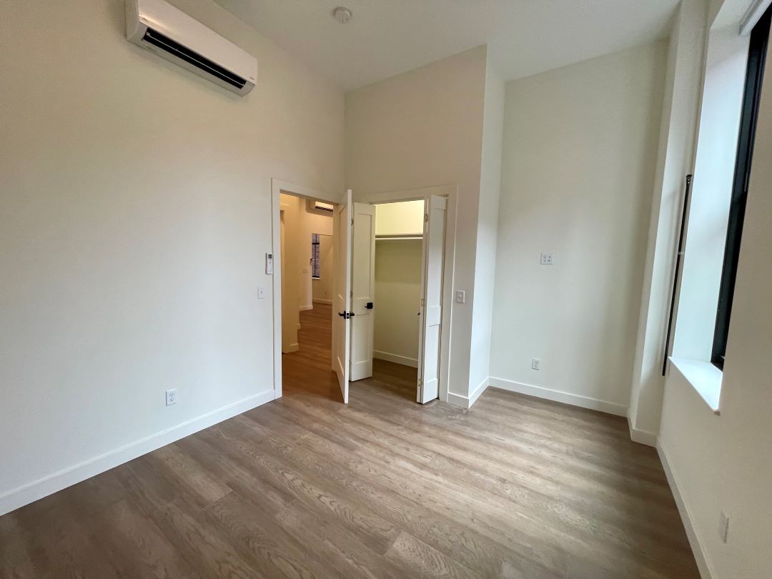 small beige bedroom with wood floors