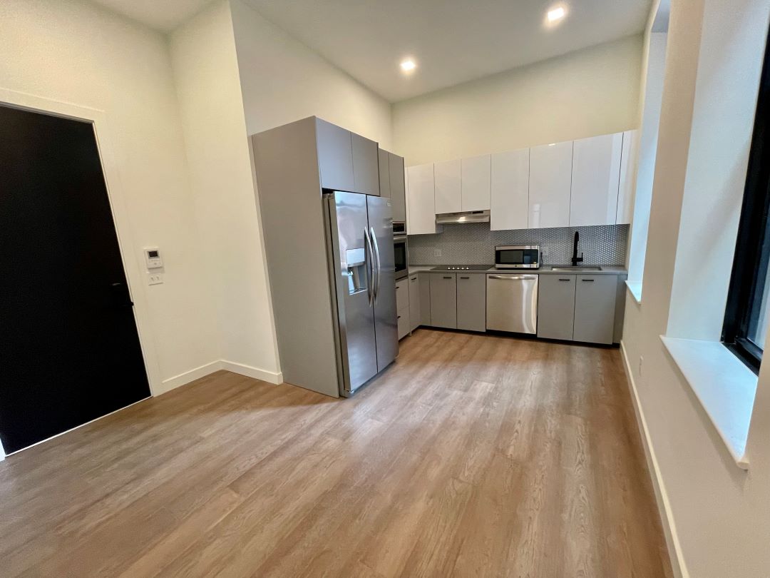 modern kitchen with hardwood floors and stainless steel appliances