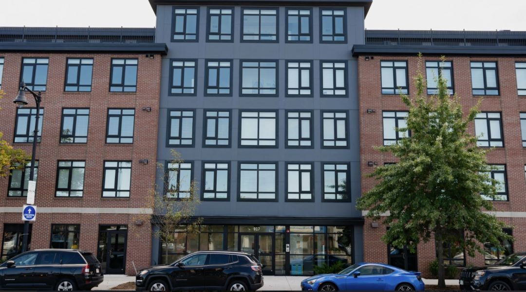 multi-story apartment building with brick exterior and large windows