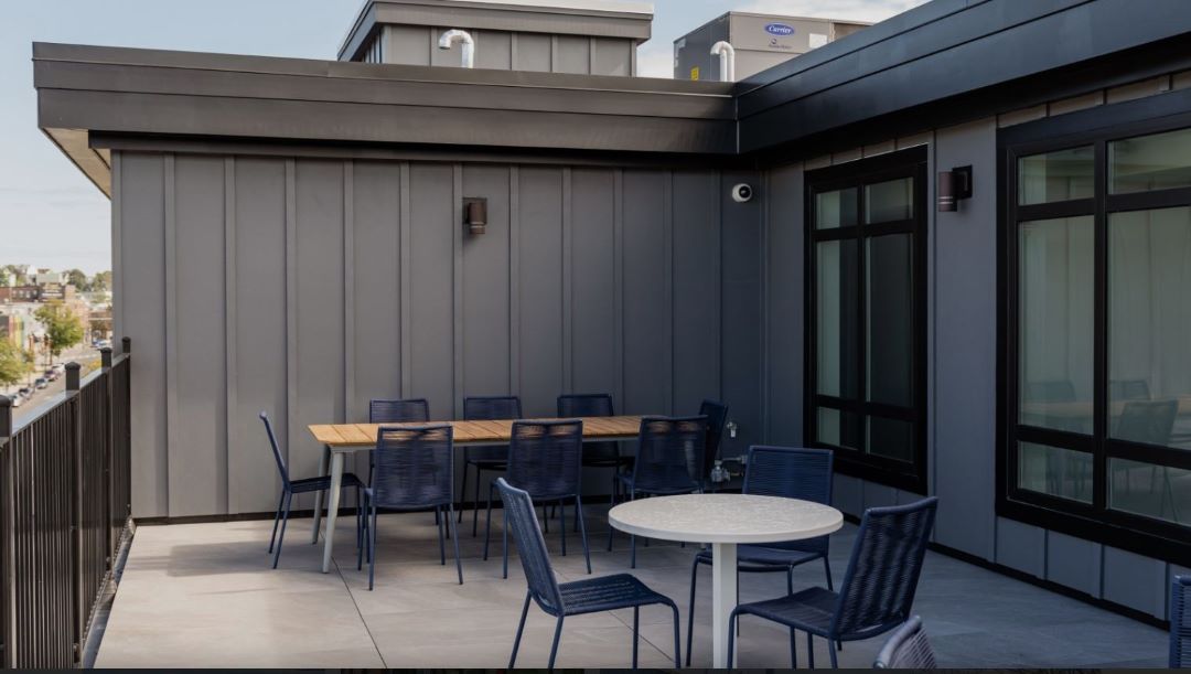 outdoor sitting area with tables and chairs on top of exterior building