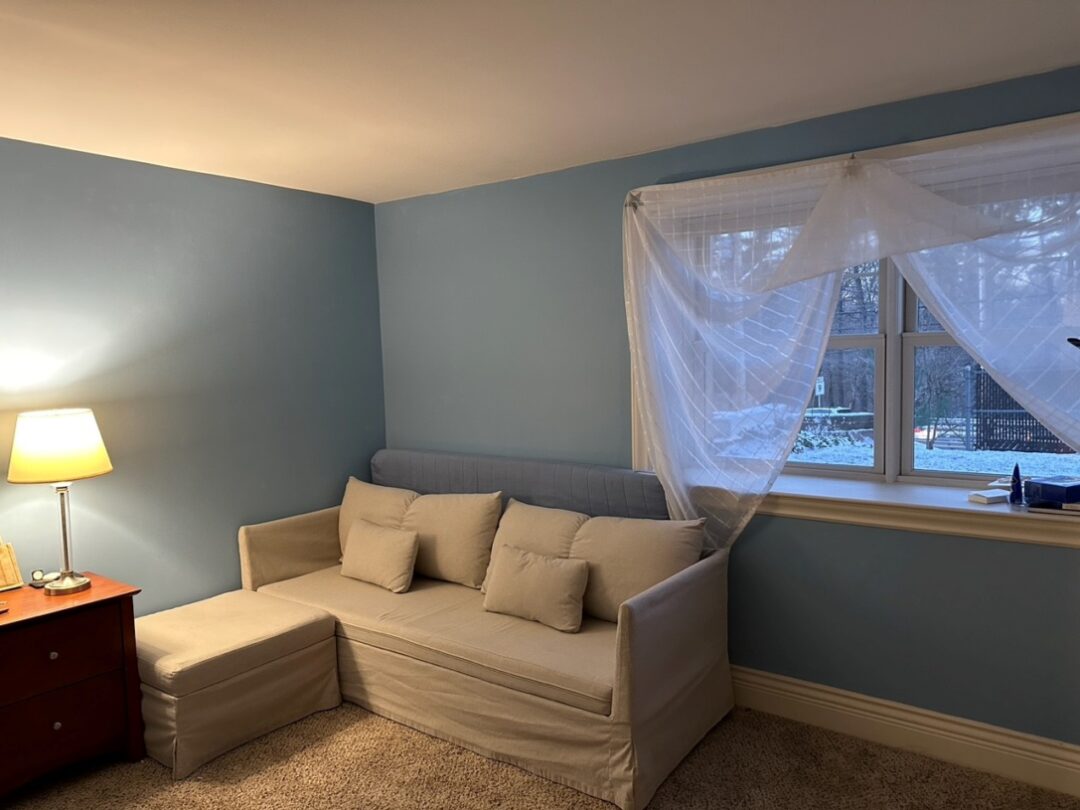 small blue bedroom with picture window and carpeting