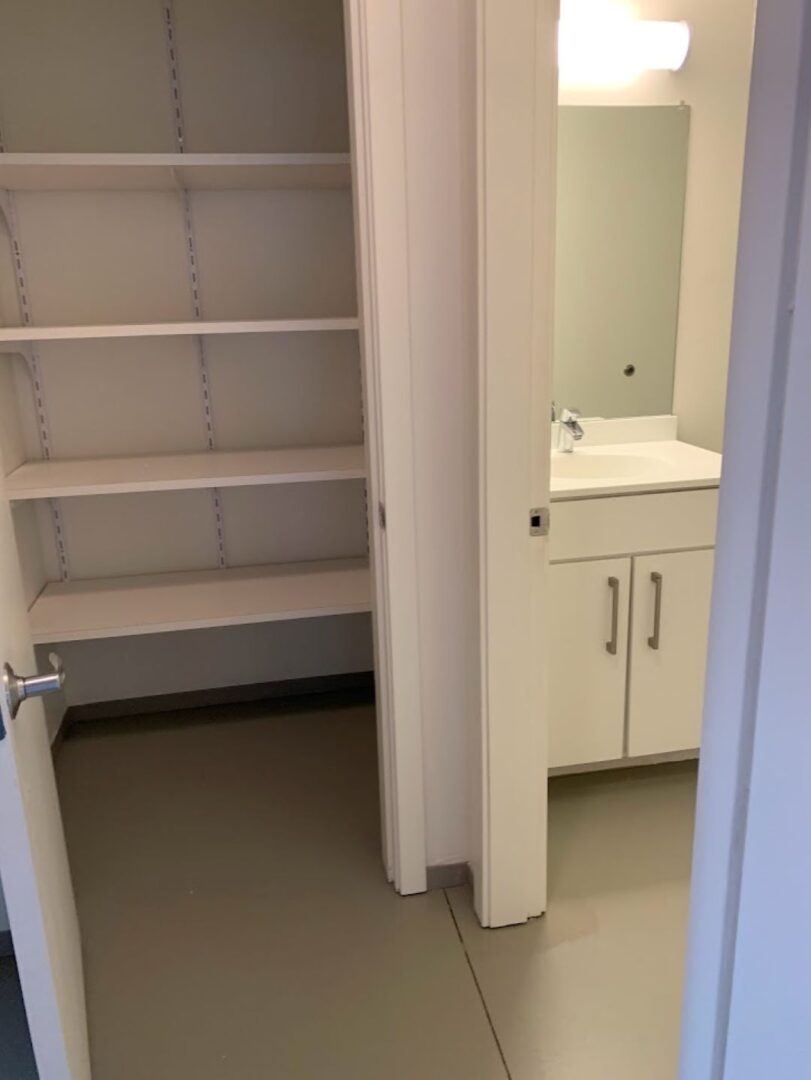 closet with shelves adjacent to bathroom