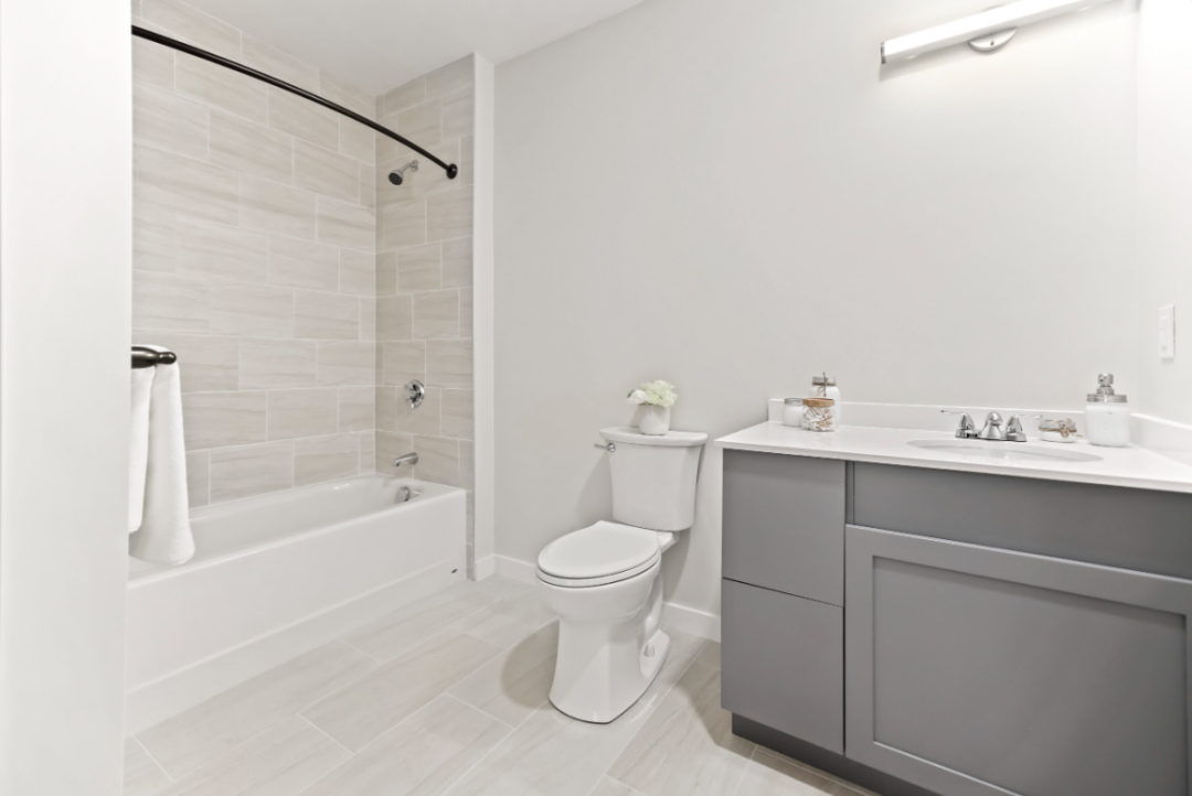 Bathroom with white-tiled tub stall