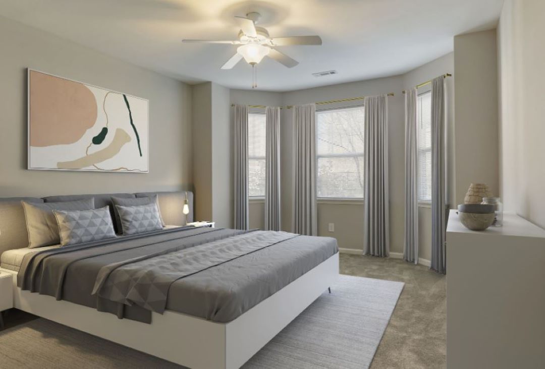 small beige bedroom with carpeting and natural light from large windows