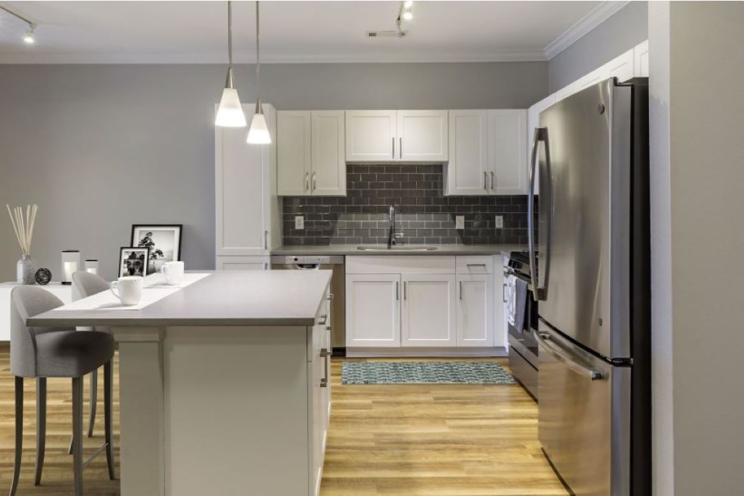 Modern kitchen with white cabinets, and stainless steel appliances