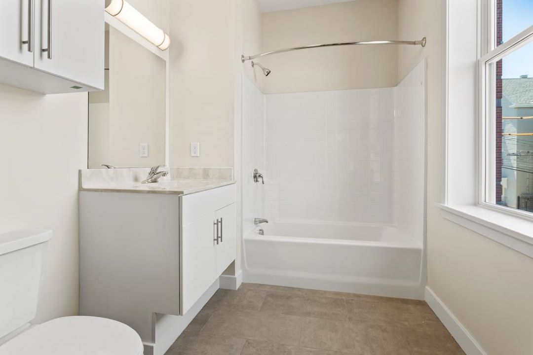 updated bathroom with full tub and tile floors