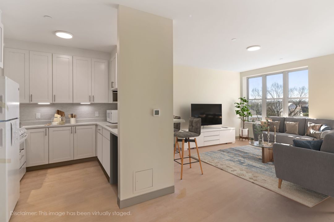open floor plan kitchen living room combo with hardwood floors, beige walls and natural light