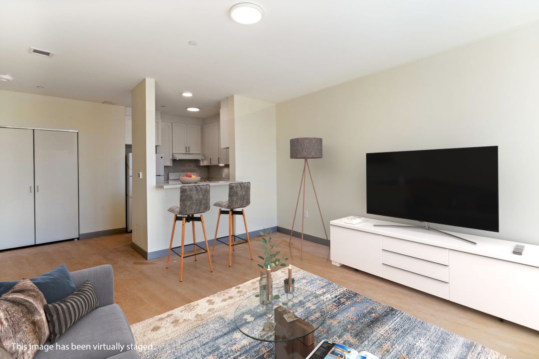 open floor plan kitchen living room combo with hardwood floors, beige walls and natural light