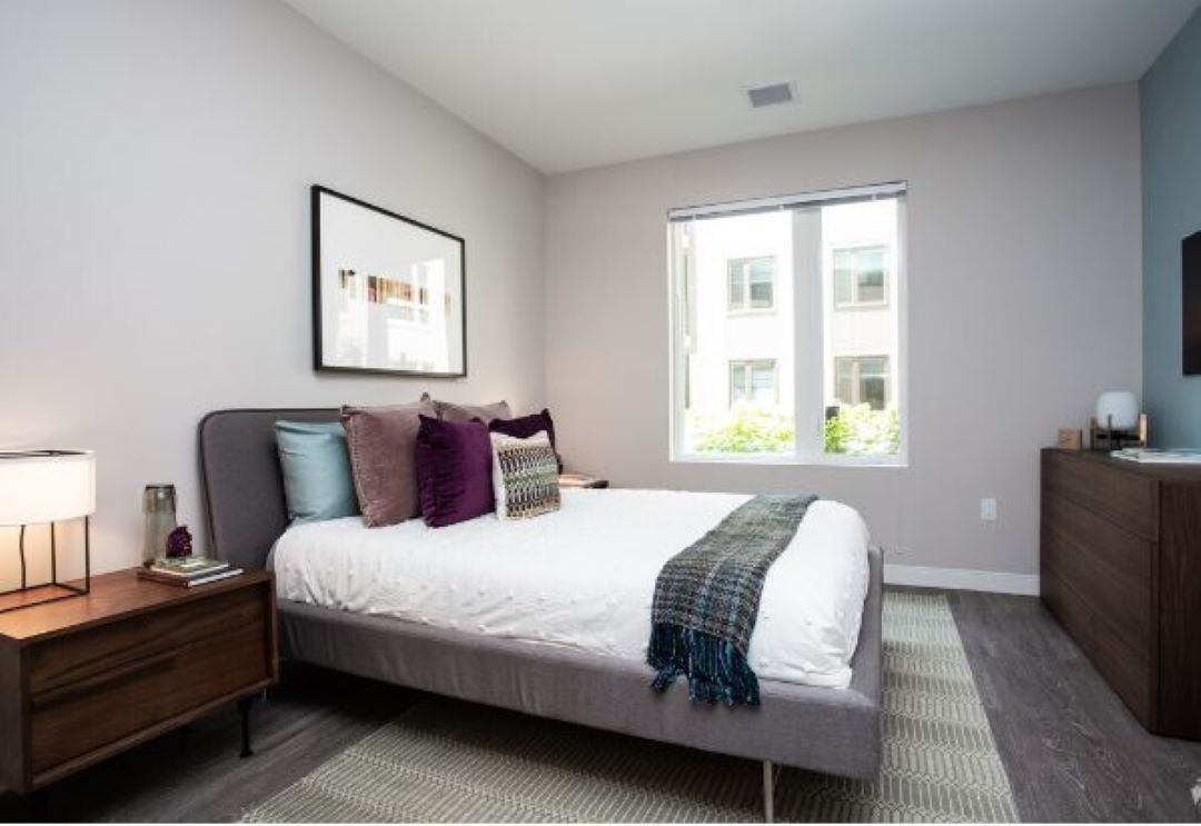 small beige bedroom with windows, and natural light