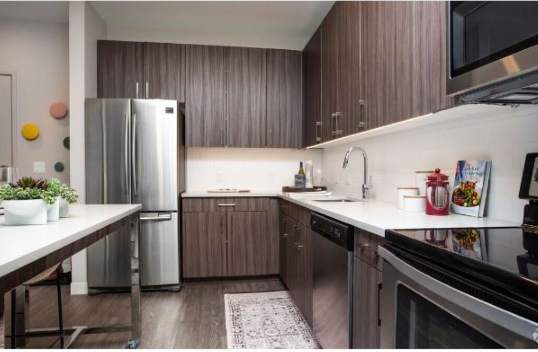 modern kitchen with wood floors, and stainless steel appliances