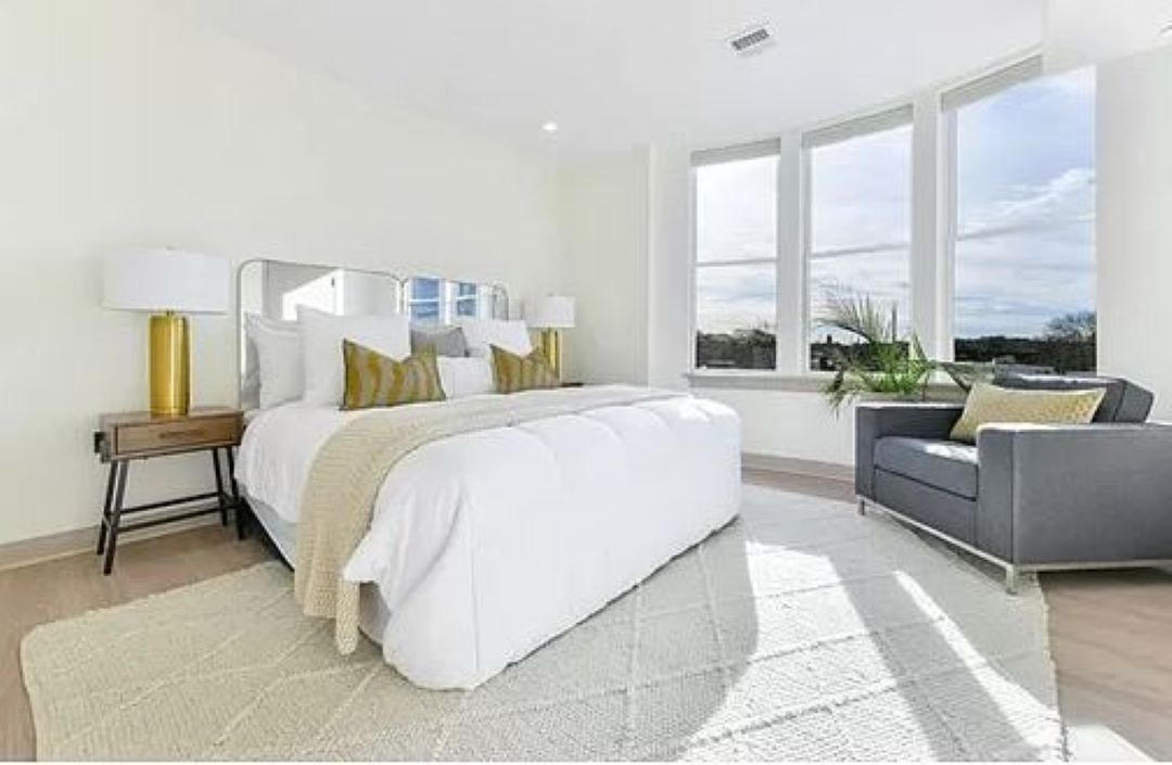 small beige bedroom with wood floors and natural light