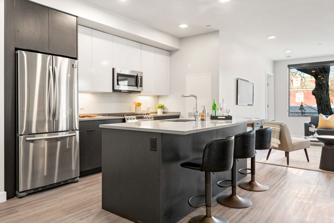 modern kitchen with stainless steel appliances, white cabinets and wood floors