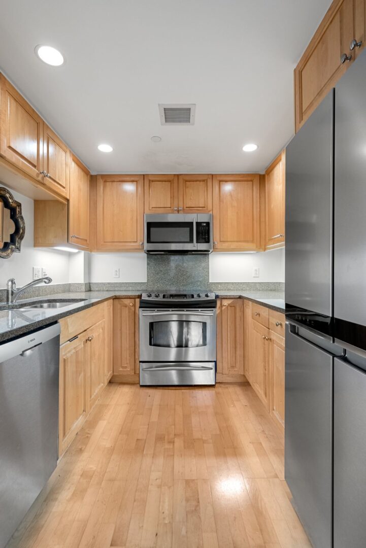 modern kitchen with stainless steel appliances and hardwood floors