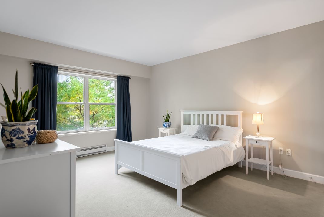 master bedroom with beige carpets and natural light