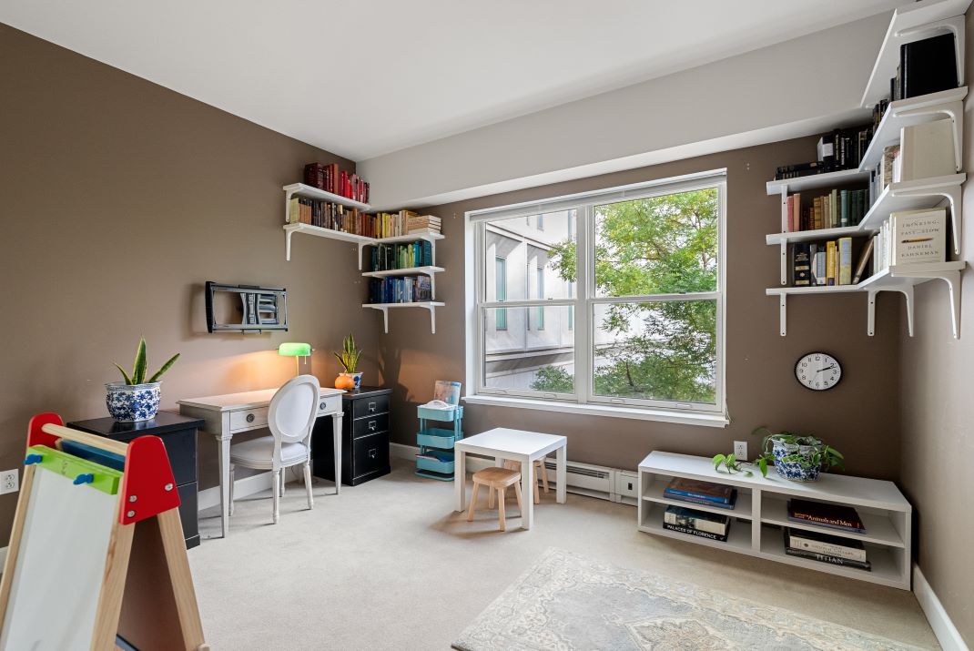 Second bedroom/ office with tan walls, carpet floors and large picture window