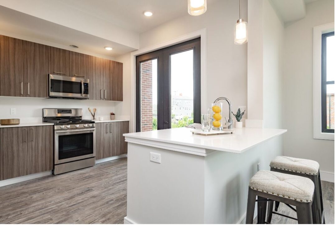modern kitchen with wood floors, stainless appliances and natural light