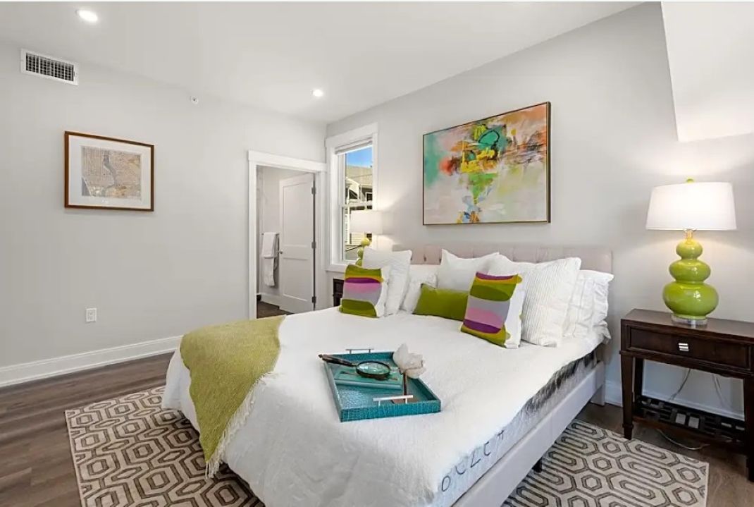 small bedroom with white walls and wood floors