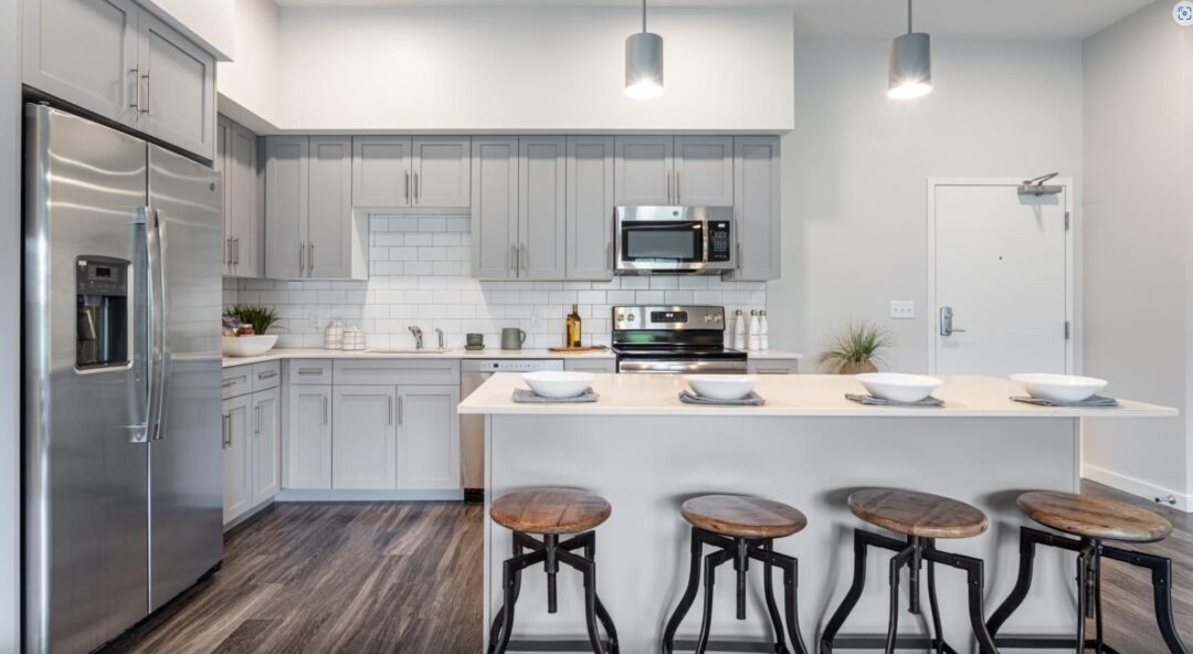 modern kitchen with white cabinets, stainless steel appliances and wood floors