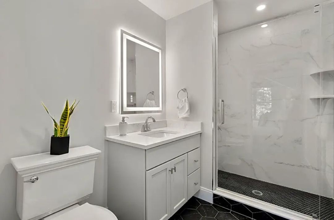 white bathroom with glass showers and title floors