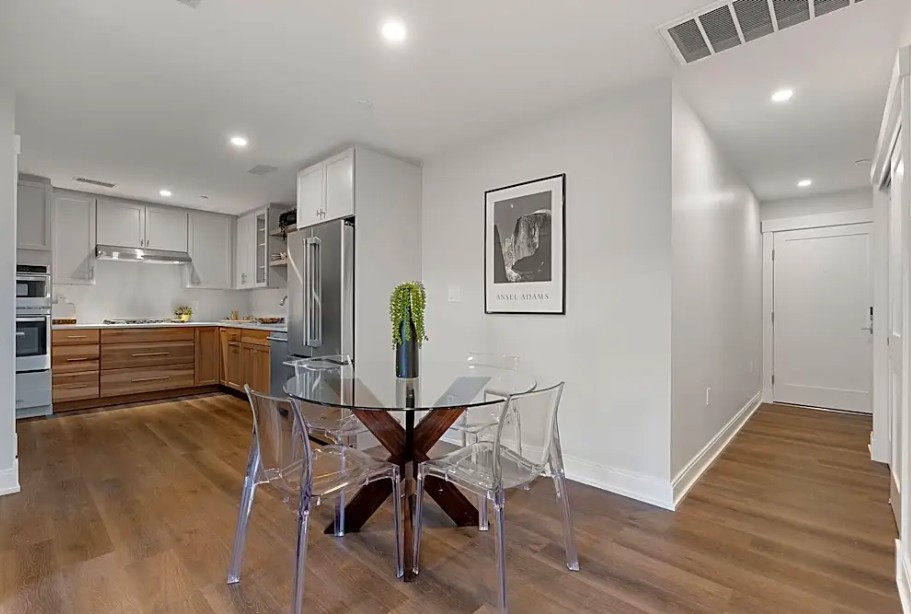 modern dining area with white walls, wood floors