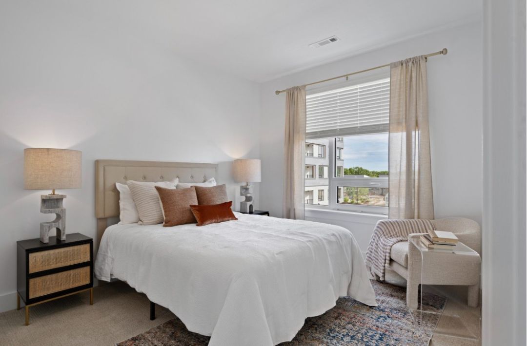 small beige bedroom with with white walls and natural light
