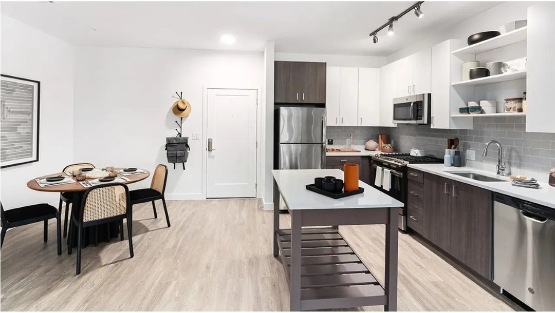 updated kitchen with stainless steal appliances, wood floors and dining area