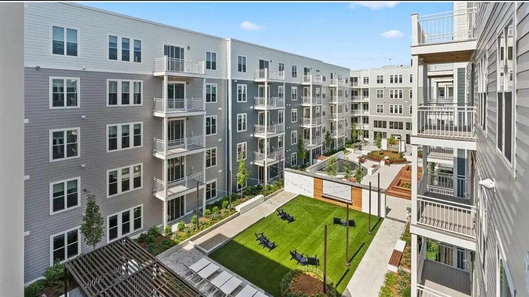 apartment style building with balcony overlooking courtyard area