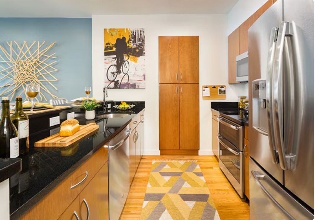modern kitchen with wood floors, stainless steel appliances