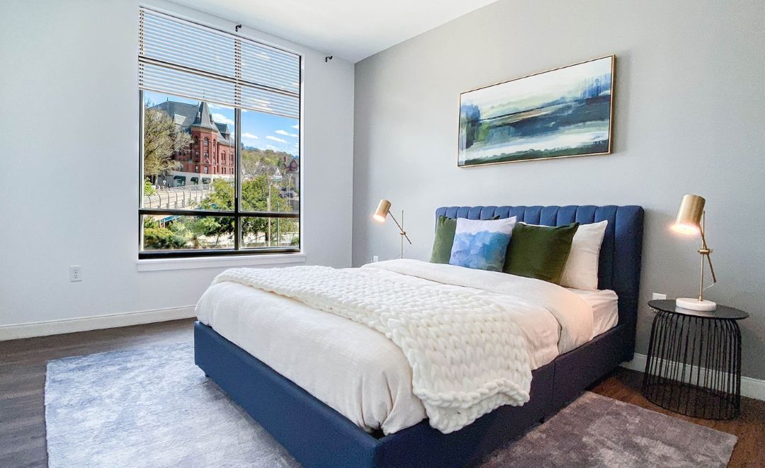 grey bedroom with wood floors and natural light