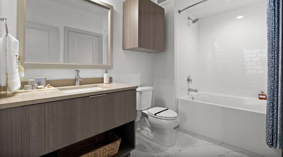 spacious bathroom with large vanity, toilet, and full bath