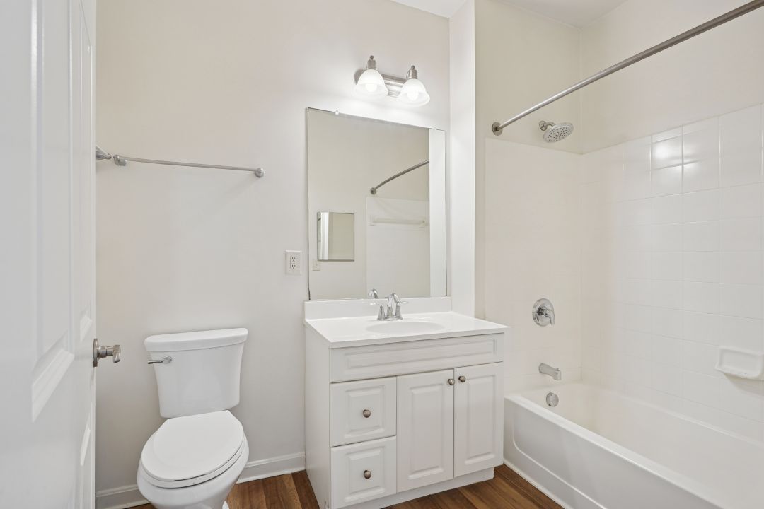 updated bathroom with white appliances and wood floor