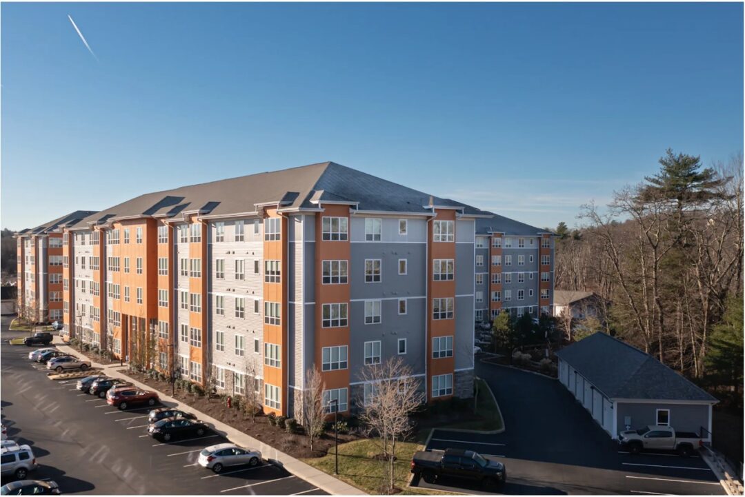 5 story apartment complex with orange and grey facade.