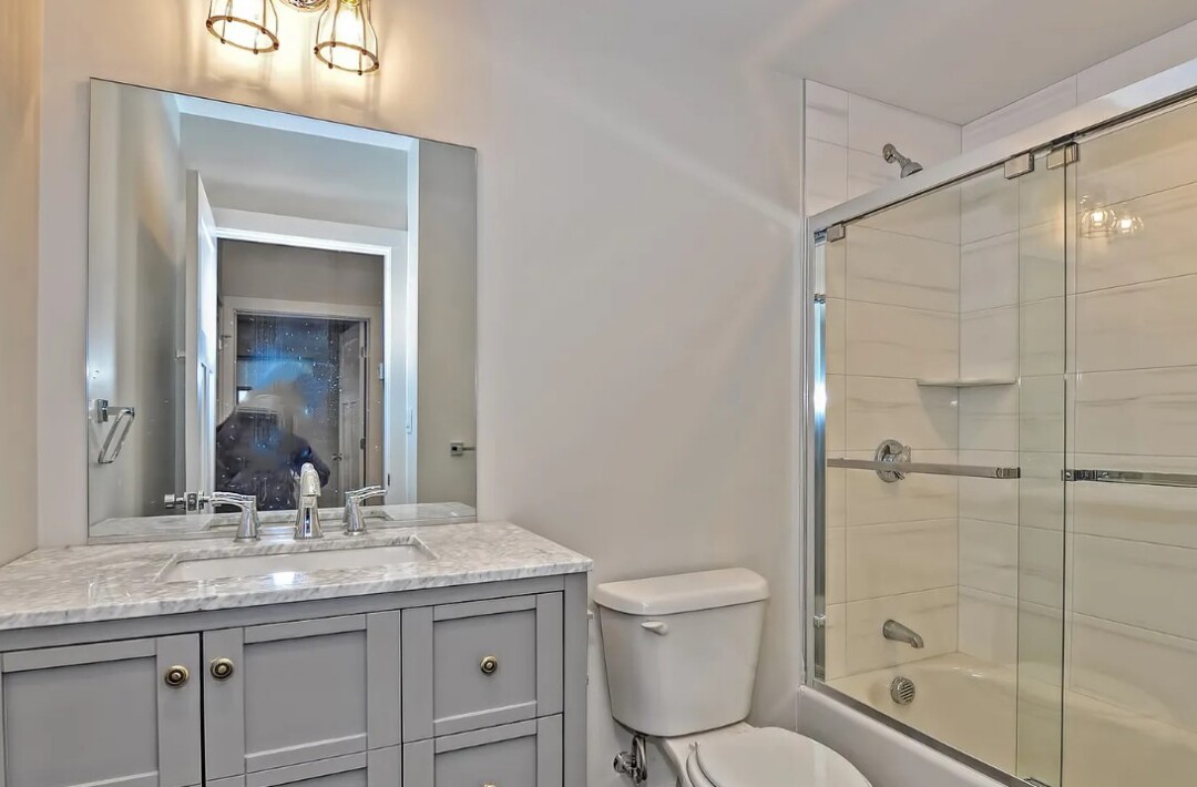 updated bathroom with grey vanity, and glass full shower