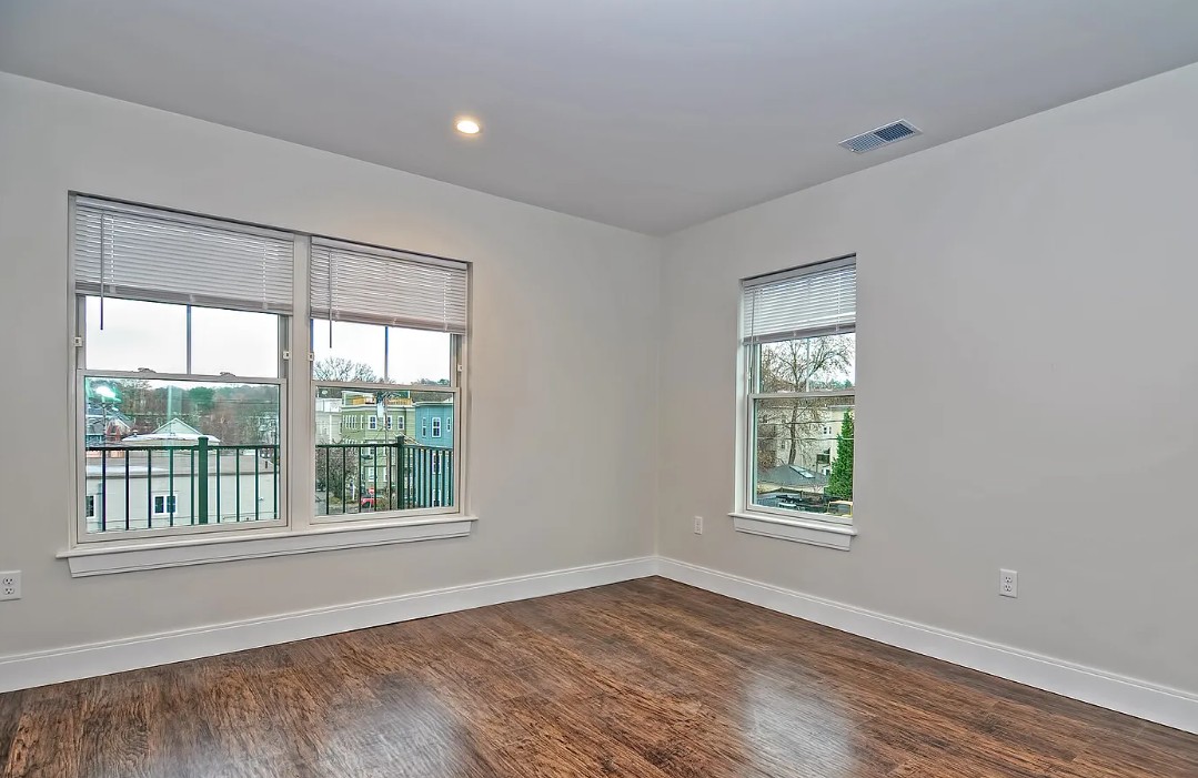 white bedroom with natural light and wood floors