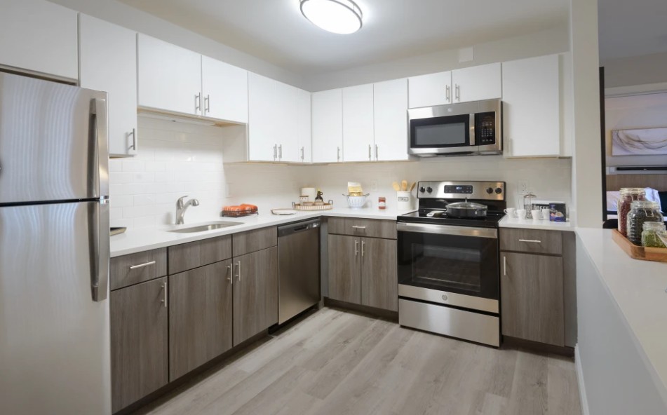 modern kitchen with white and brown cabinets, stainless steel appliances and wood floors