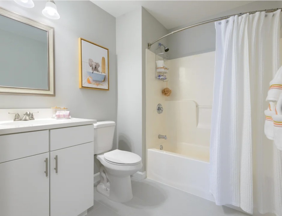 Modern bathroom with white vanity cabinet, bathtub, and gray painted walls