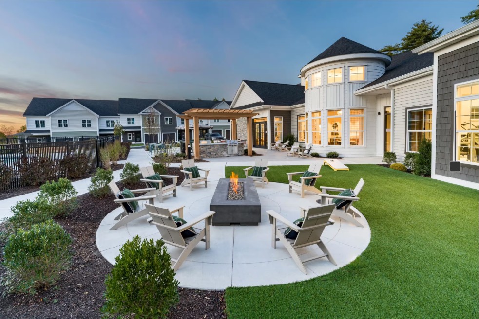 Landscaped outdoor courtyard with circular seating areas, lounge chairs, and fire features.
